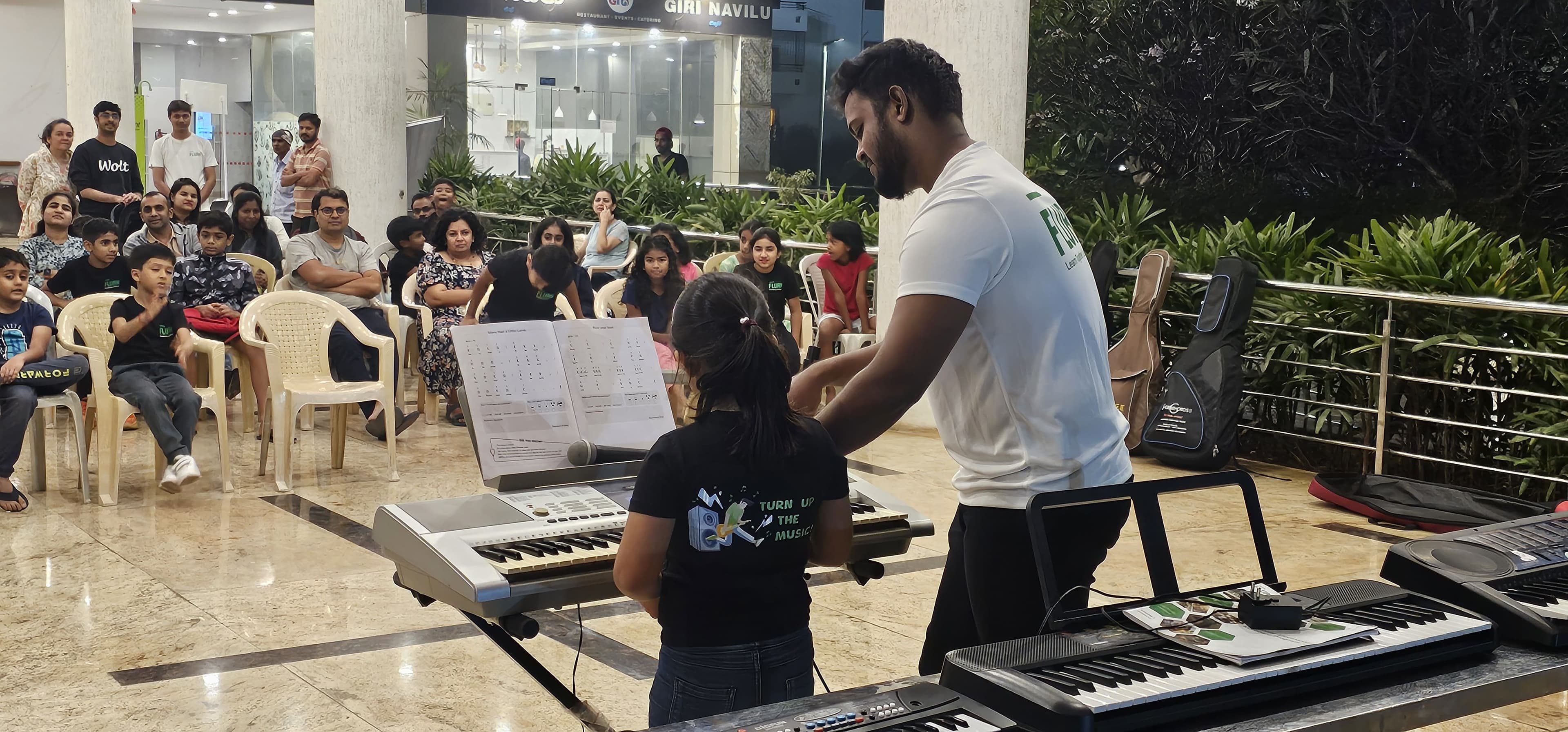 Flurn teacher guiding a child at a community keyboard class