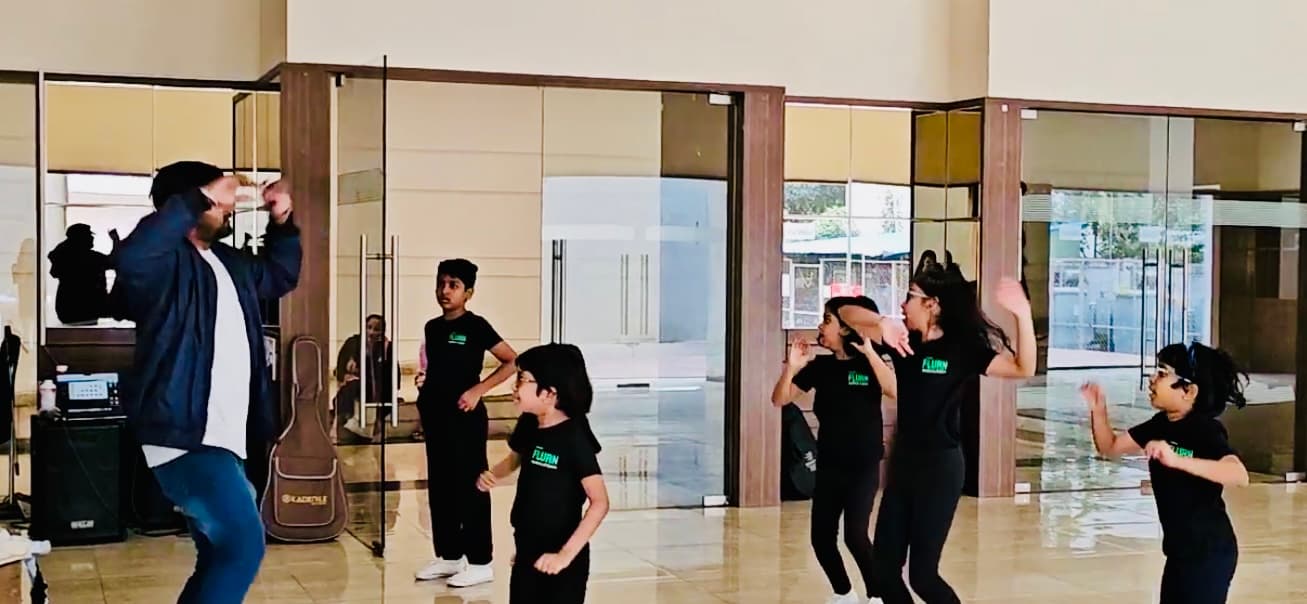 Teacher leading children in a dance class inside an apartment clubhouse